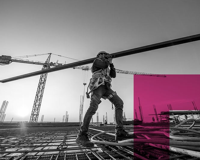 Construction worker lifting pole on construction site