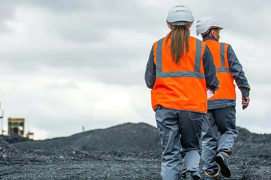 Two miners walking in mine site