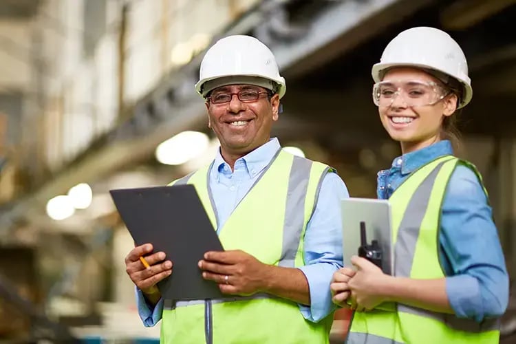 Two workers on site with hard hats
