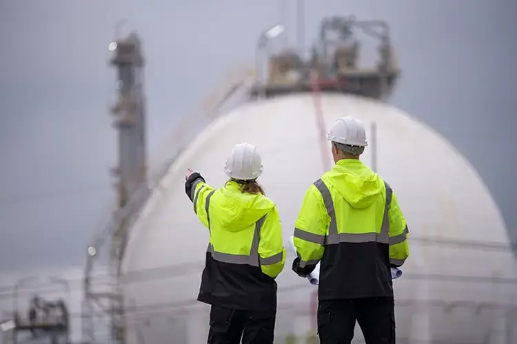 Two men in high vis looking at work site