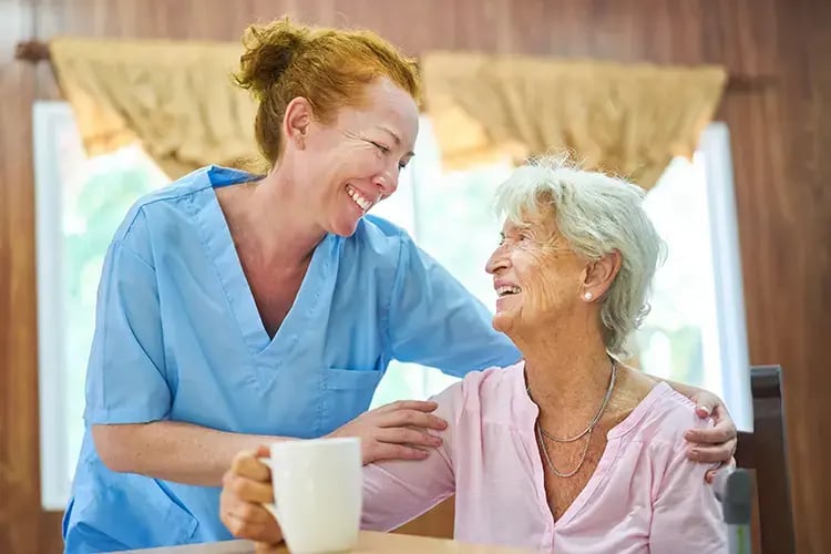 Aged care nurse smiling at elderly woman