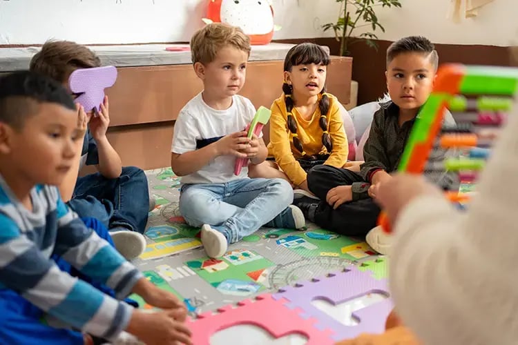 Young children looking at teacher