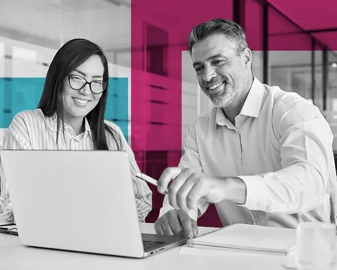 Man and woman in office looking at laptop