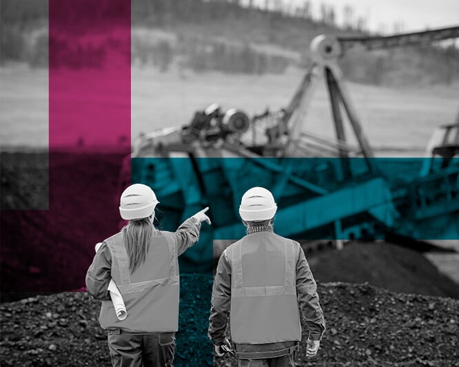 Two contractors looking at machinery in a mine