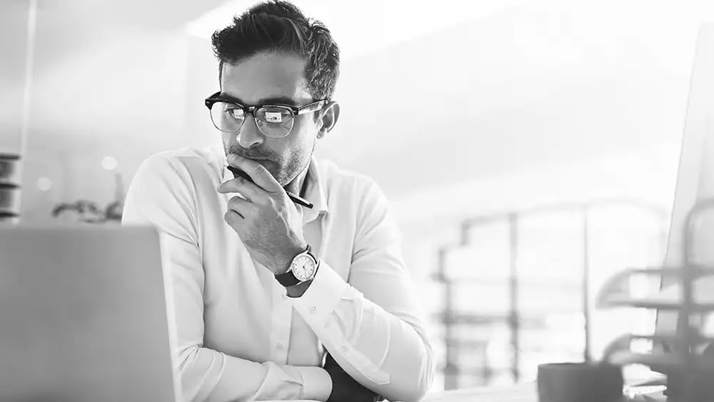 Man with glasses looking at laptop