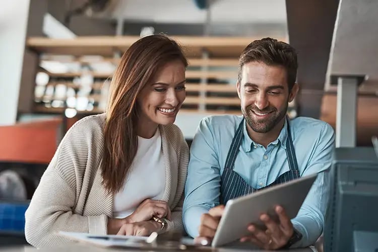 Two people looking at an ipad in cafe