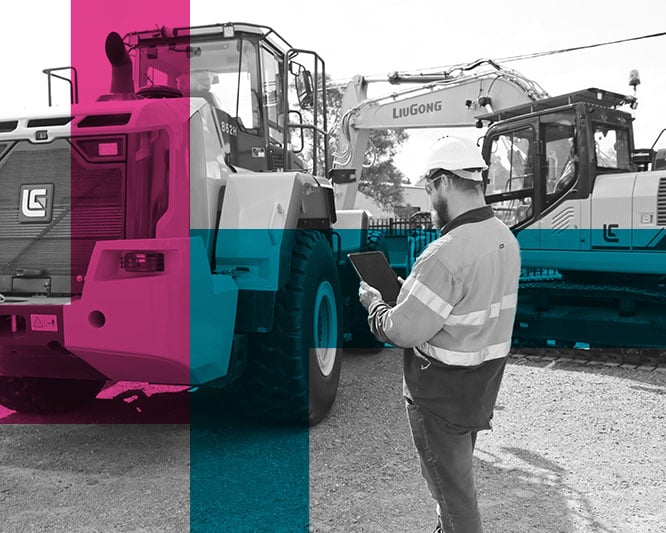 Tradesman inspecting parked excavator with ipad