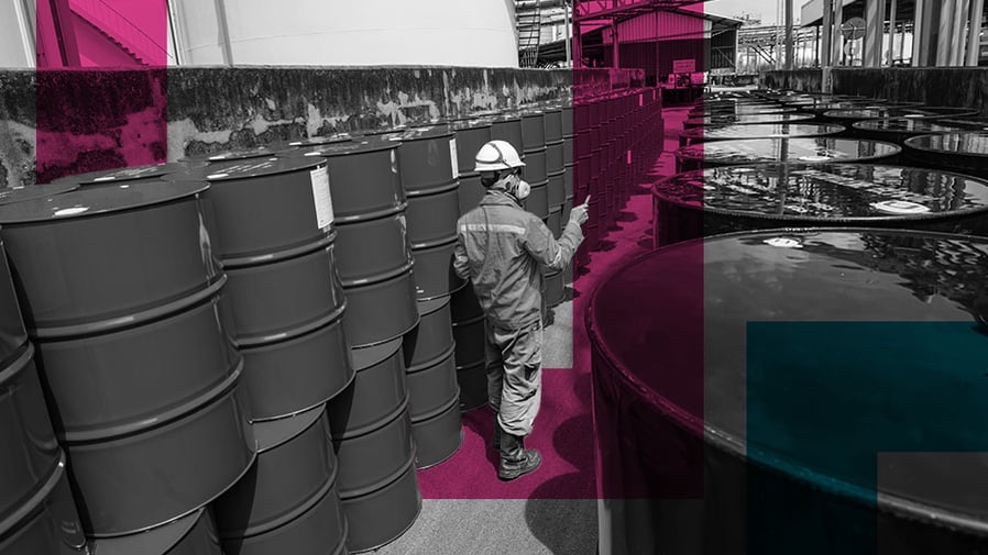Man on work site looking at hazardous substances in drums