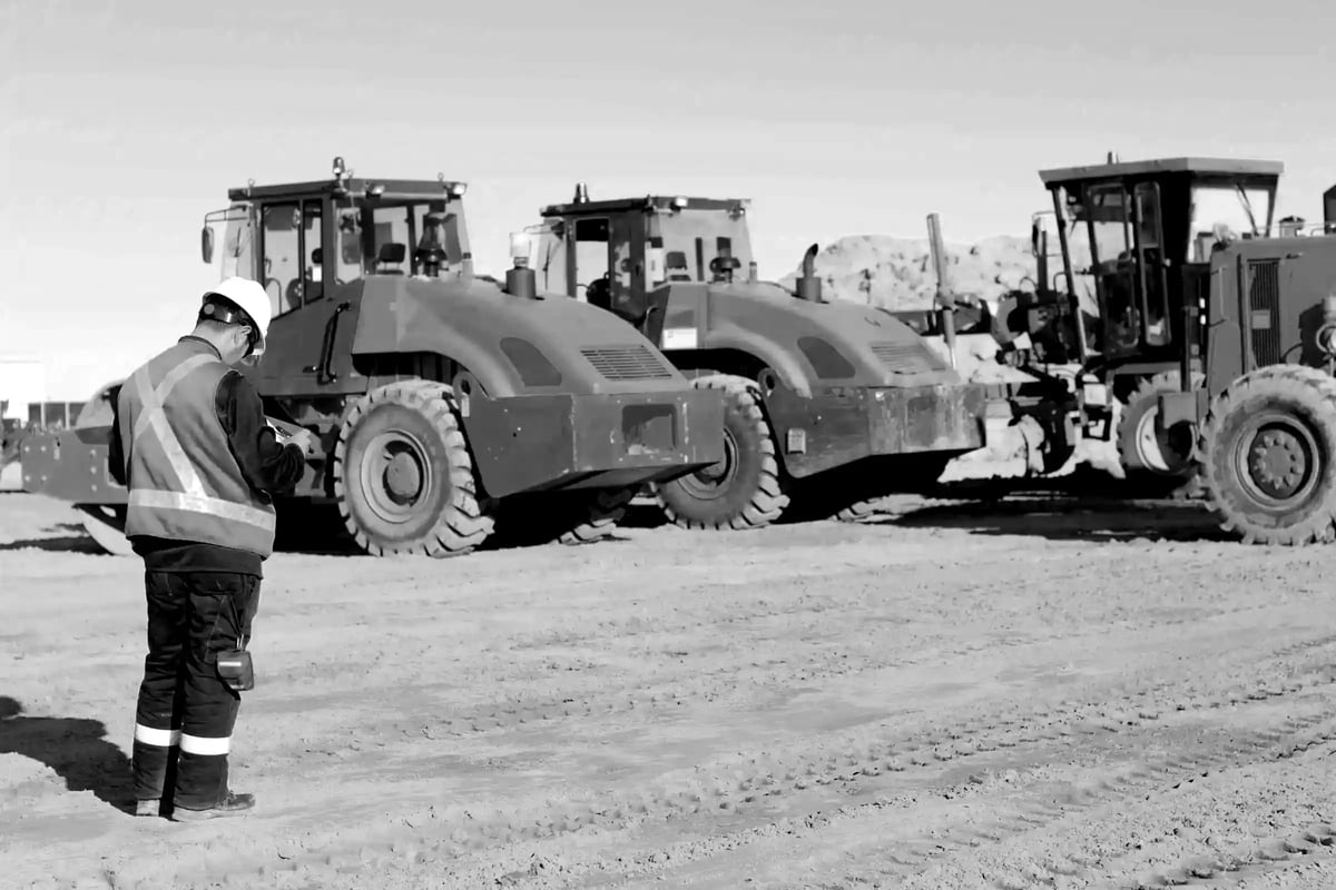 Man in ppe assessing a machine on a work site