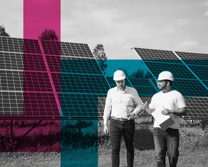 Two people with hardhats walking in front of solar panels